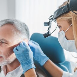 Man getting his ears examined by a medical professional.