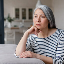 Woman looking despondent sitting at her kitchen counter.