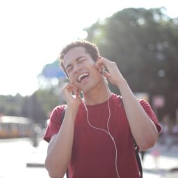 Young man listening to music on his headphones while outside.
