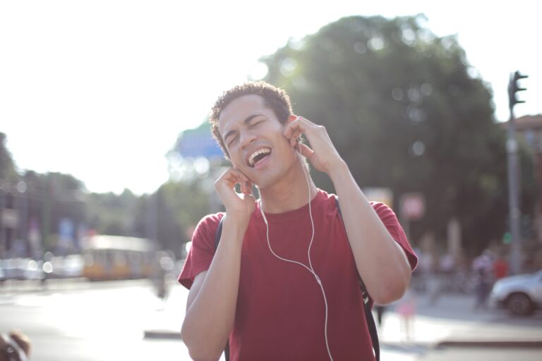 Young man listening to music on his headphones while outside.