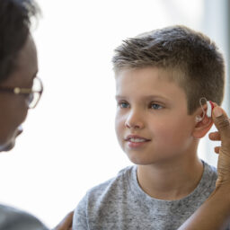 Young boy wears a hearing aid